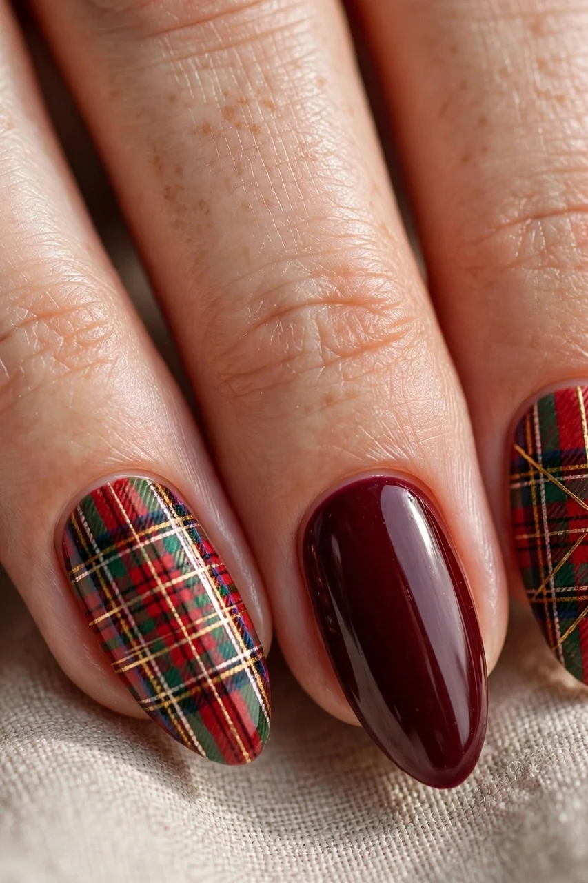 Tartan plaid accent nails with solid burgundy nails and a gold pinstripe for Christmas